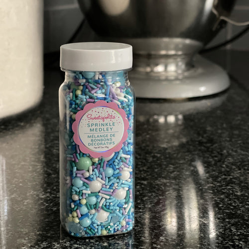 small jar filled with blue white green and lilac sprinkles 
